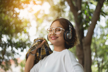 A young girl lying on the grass listening to music, relax on soft and blurred background