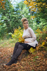 Obraz premium Young pregnant woman in nature enjoying autumn sun outdoors.