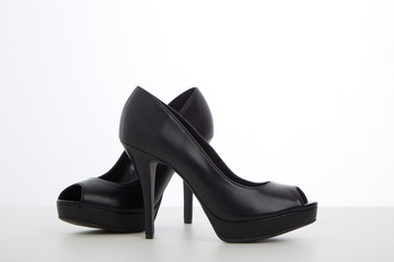 Fototapeta premium black high-heeled shoes on white