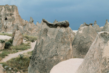 Erosion formations in the valley of Cappadocia, Turkey. Path with green grass among the mountains.