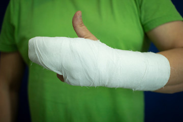 Fototapeta na wymiar A man with a cast on his arm.Man's hand in bandages after surgery.