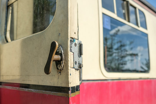 Close-up view of the old slam-door passenger train door handle, seen in the opened position, on a first class passenger train car.