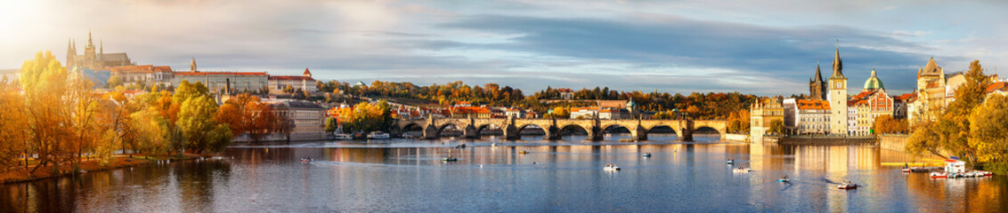 Obraz premium Panorama der berühmten Karlsbrücke über die Moldau in Prag, Tschechien, bei goldenem Sonnenuntergang im Herbst