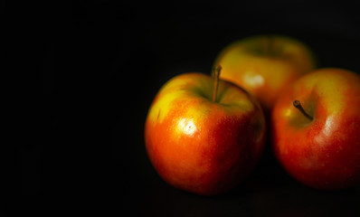 Drei Äpfel mit dunklem Hintergrund