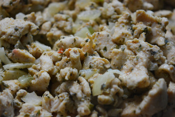 Finely chopped pieces of homemade chicken breast, fried and stewed with onions and sunflower oil. Slices of delicious, juicy chicken lying on a black skillet while frying.