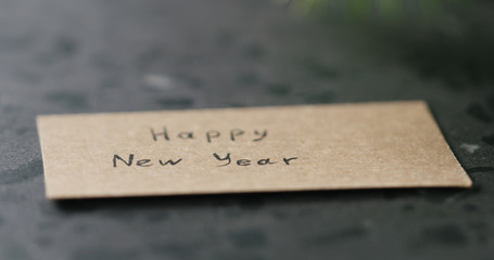 happy new year card next to spruce twig