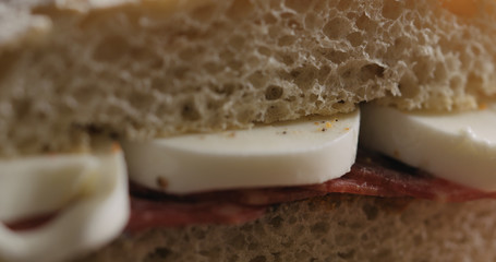 Extreme closeup put top on slami mozzarella sandwich