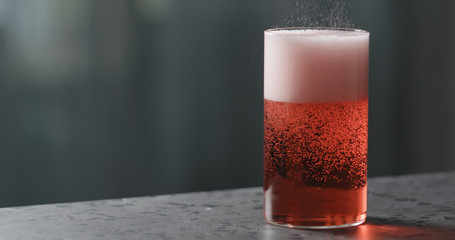 pour berry cider into glass on terrazzo countertop with copy space