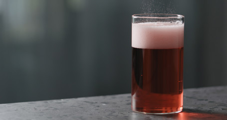 berry cider into glass on terrazzo countertop with copy space