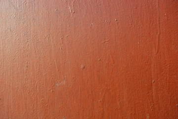 Old metal building sheet covered with brown paint with a golden tint in bright sunlight. Interesting structure and texture with gilding.