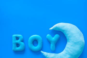 Fototapeta premium Baby shower concept. Word Boy and moon toy on blue background top view space for text