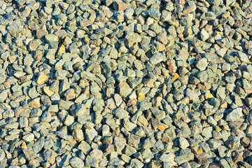 Building materials for construction and repair work, clean fine gravel rubble, a pile of building pebbles in the autumn sunlight.