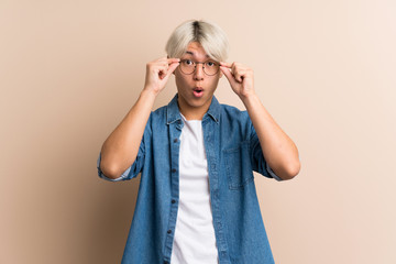 Young asian man over isolated background with glasses