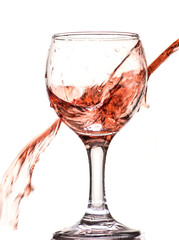 a splash of red wine in a glass on a white background