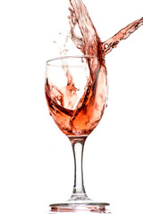 a splash of red wine in a glass on a white background