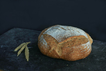 Fresh homemade bread. round bread on a dark background. Mother dough bread. Homemade bread sourdough, rustic baked bread