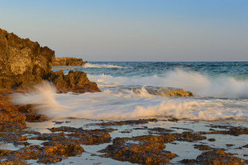 Sea evening landscape with a rocky shore and waves