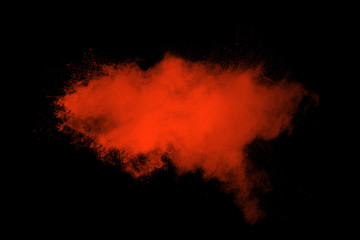 Red color powder explosion on black background.Freeze motion of red dust particles splashing.