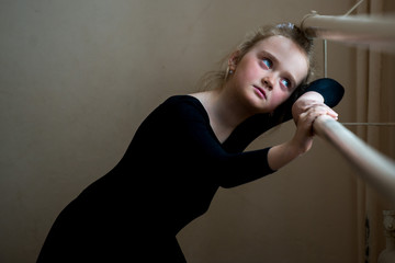 Tired young ballerina. Portrait of a cute little girl in a ballet class.