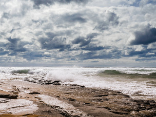 Beautiful Fanore beach, Yellow sand, blue water and cloudy sky, Waves rushing towards the coast, County Clare, Ireland.