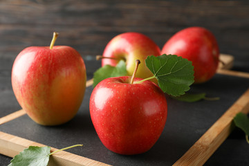 Apples and cutting board on wooden background, space for text