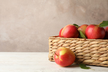 Basket with apples on white wooden background, copy space