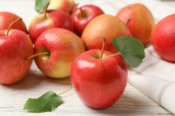 Apples and towel on white wooden background, close up