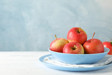 Composition with plate and apples on white wooden background, copy space