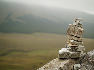 Stone balance tower against mountains blurred background. Selective focus, copy space. Concept...