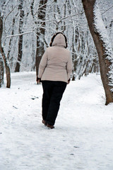 Woman walking alone in the winter park outdoor