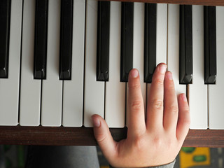 Practicing on piano, Teenager's hand, black and white keys, Concept developing finger's motion skill,