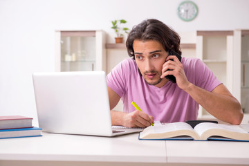 Young male student preparing for exams at home