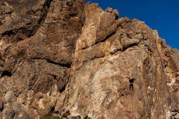 rear view of rock climber on a vertical wall