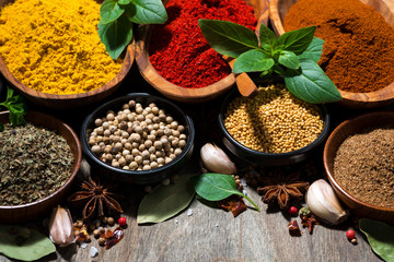 assortment of various spices and herbs on a wooden background, closeup