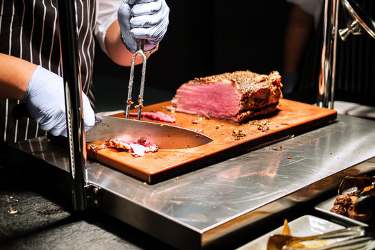 chef cutting meat in restaurant