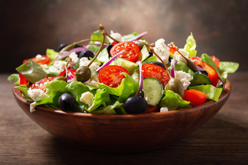 Fototapeta na wymiar bowl of fresh salad with vegetables, feta cheese and capers