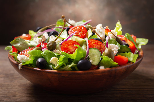 bowl of fresh salad with vegetables, feta cheese and capers