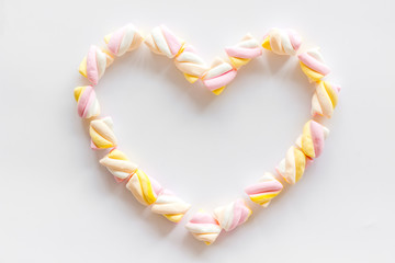 Pastel marshmallows background. Heart shaped set of sweets on white table top view mockup copy space