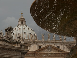 Piazza San Pietro fountain in Rome with the dome and a detail of the church.