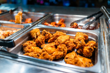 Fried chicken thighs buffet bar self serve with tongs in grocery store, restaurant or catering...