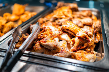 Roasted chicken wings buffet bar self serve with tongs in grocery store, restaurant or catering...