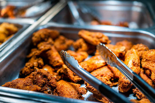 Fried chicken buffet bar self serve with tongs in grocery store, restaurant or catering event with crisp skin and unhealthy food