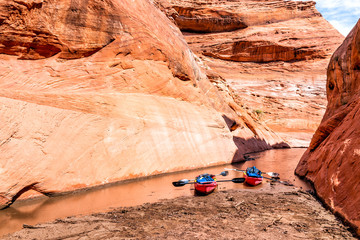 Kayaks by trailhead of hiking trail in Lake Powell narrow and shallow antelope canyon with dirty muddy water and rock formations © Kristina Blokhin