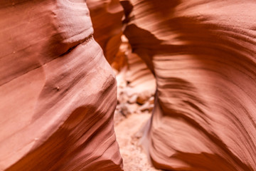 Orange red wave shape abstract formations rocks shadows view at narrow Antelope slot canyon in Arizona on path footpath trail from Lake Powell