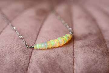 Natural opal gemstone necklace on pink velvet