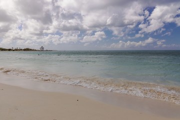 White sand beach and turquoise water  ocean on blue sky background. Aruba.  Beautiful backgrounds.