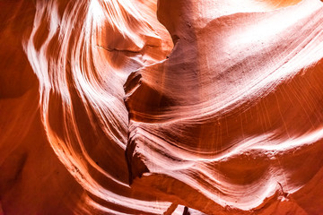 Abstract closeup view of shadows and light waves at upper Antelope slot canyon with shape formations of red rock layers sandstone in Page, Arizona