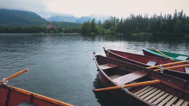 Kayak Boat on Calm Clear Mountain Summer Lake. Resort Hotel in Pine Woods. Idillyc View of Mountainous Forest. Europe Slovakia Tatry. Floating Canoe with Paddle Static Shot. Footage Shot Full HD