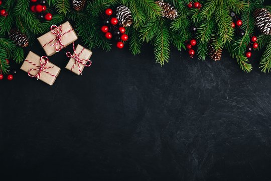 Christmas tree decoration background with fir cones,  red berries and presents.