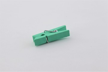 Little green clothespin on a gray background.